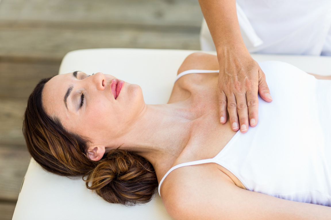 Calm woman receiving reiki treatment