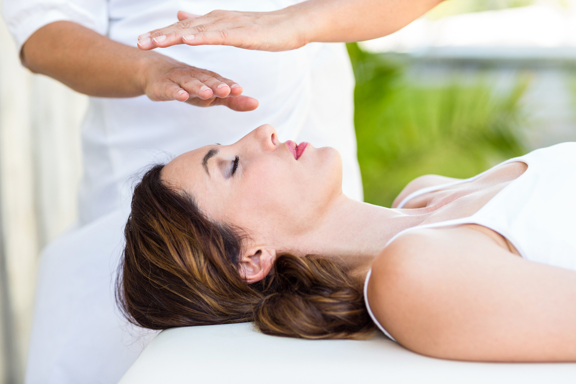 Calm woman receiving reiki treatment